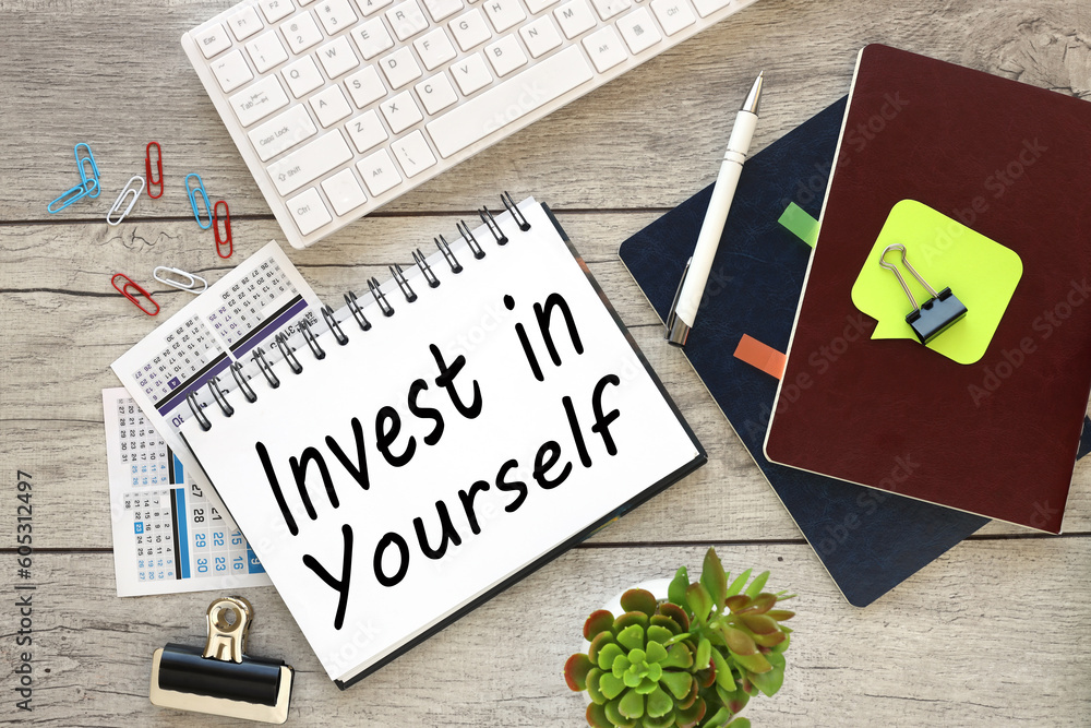 Poster light background. white keyboard.calendar. text invest in yourself on notepad