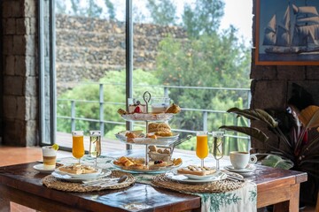 Table set up for breakfast with a pastry stand, toast, coffee and orange juice on it