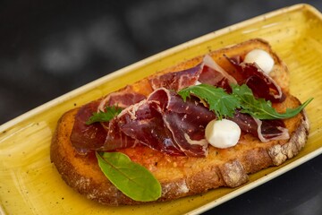 Closeup of a bruschetta with roast beef in a special plate