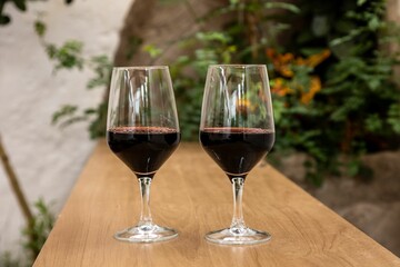 Closeup shot of two glasses of red wine on a wooden surface