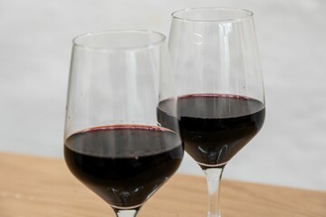 Closeup shot of two glasses of red wine on a wooden surface