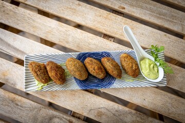 Closeup of falafels with green sauce