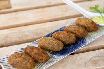 Closeup of falafels with green sauce