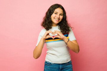 Loving teenager feeling in love making a heart gesture