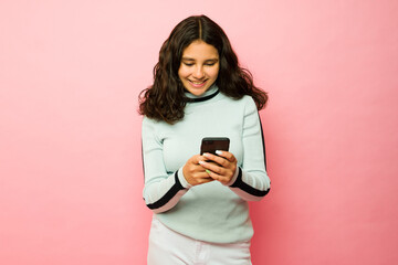 Happy teenager texting on the smartphone smiling