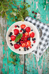 Dry oatmeal with strawberries and blueberries, top view