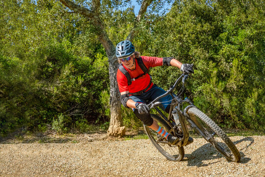 Mountain biker takes a turn at an angle and in a professional position. Sporty and dynamic image that reproduces enduro mountain biking