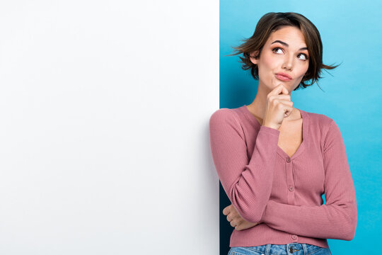 Photo of thoughtful minded smart woman with bob hairdo dressed pink sweater look empty space promo isolated on teal color background