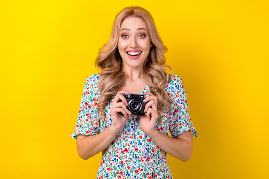 Portrait of positive lovely lady wear trendy sarafan hold camera spend free time hobby take picture isolated on yellow color background