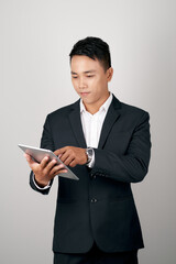 A handsome young businessman using a digital tablet on white background.