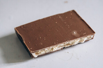A piece of dark chocolate bar lies on the table