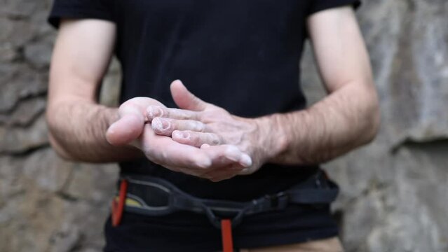 Climber man coating his hands in powder chalk magnesium. Ready for climbing 4K