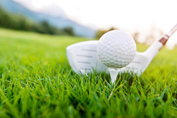Golf club and ball on green lawn