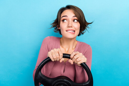 Photo of young girl guilty bite lips looking empty space hold steering wheel mistake on road accident isolated over blue color background