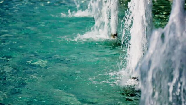 Fountain jets in slow motion, blue water.