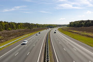 Dutch six lane highway with a few cars seen from above with infrastructure through natural reserve...