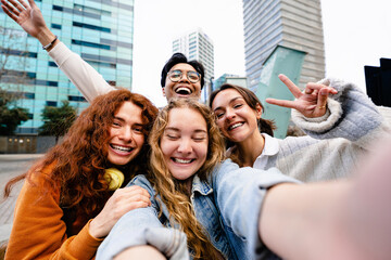 Young friends taking selfie picture with mobile phone outdoors in the modern city - Blond girl making self portrait of buddies - Powered by Adobe