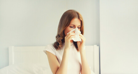 Portrait of sick upset woman sneezing blow nose using tissue