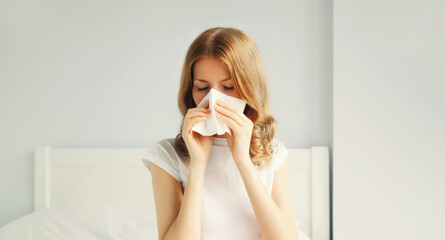 Portrait of sick upset woman sneezing blow nose using tissue
