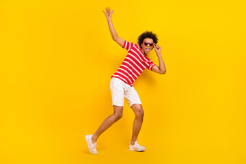 Fototapeta na wymiar Photo of funky guy dance vacation active person carefree wear sun glasses shirt pants shoes isolated yellow color background