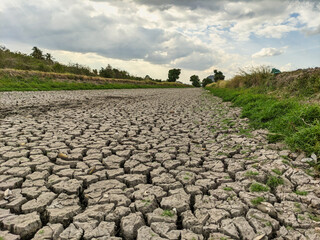 Dried riverbed during drought season with parched and cracked soil.
