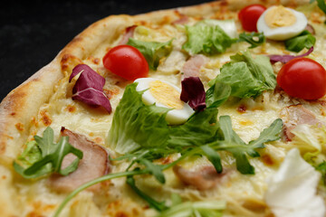 pizza with meat. tomatoes, quail eggs, and herbs. deluxe pizza