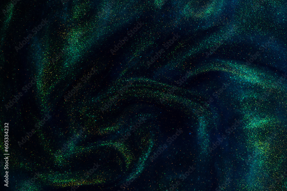 Wall mural gold particles in blue fluid. golden sparkling dust particles floating in a blue liquid with green t
