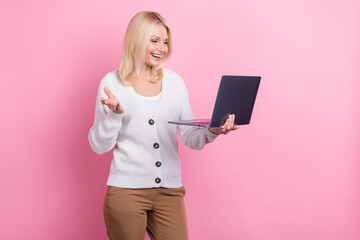 Portrait of optimistic satisfied person blond hair dressed white sweater look at laptop talk video call isolated on pink color background