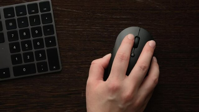 Computer work. Hand clicks the mouse close up. Desk top view. 4K footage