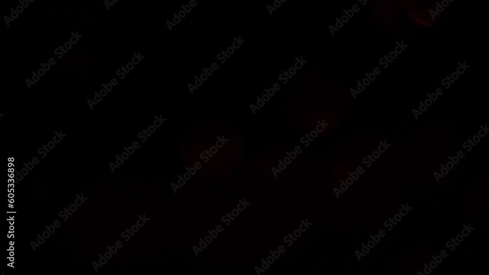 Wall mural abstract red bokeh background. red bokeh fades in and out on black. smooth movement of illuminated s