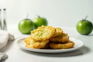 Delicious fried green tomatoes in cornmeal and breadcrumbs stacked on plate. Traditional Southern...