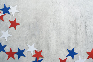 4th of July background. USA paper fans, Red, blue, white stars and confetti on gray old concrete...