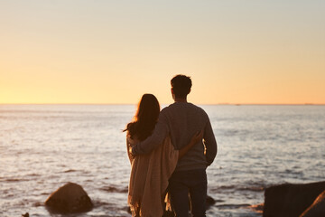 Hug, sunset and couple relax on beach in evening on holiday, summer vacation and weekend by ocean....