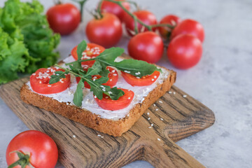 Sandwich with cheese, tomatoes and arugula.