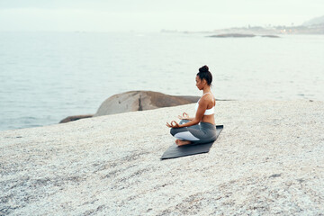 Yoga, meditation and woman on a beach with lotus pose, wellness and fitness. Pilates, sea and female person on sand with peace in nature feeling relax and calm with spiritual and holistic mockup