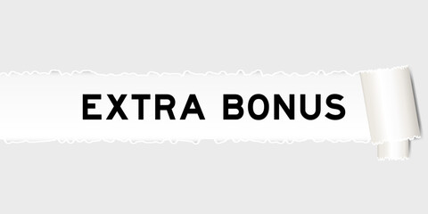Ripped gray paper background that have word extra bonus under torn part