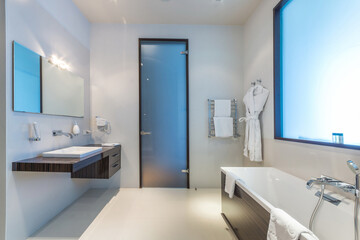 Laconic design of the hotel bathroom, with a frosted glass door, false window and stylish...