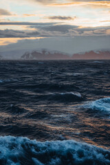 The Midnight sun over the icebergs of the Drake Passage near the Antarctic Peninsula in Antarctica.