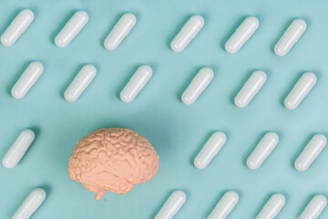 Brain and pills on a blue background. The concept of medicine, memory, concentration. Drugs to improve brain function.