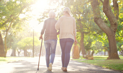 Walking, park and and woman with elderly mother for bonding, assistance and help outdoors. Nature,...