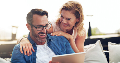 Couple, happy and tablet for funny movie, streaming or laughing at meme or comedy on sofa. Woman, man and relax together on holiday with technology, watching tv show on stream service on mobile app