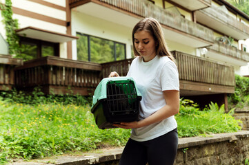 close-up of a carrier with a cat in female hands outside. transporting a cat with a carrier....