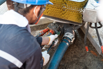 The technician worker is connecting the hydualic line with skimmer unit, the oil spill recovery...