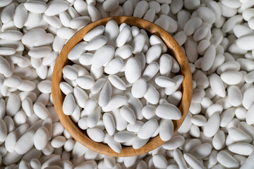 Almond candy. Sugar coated almond candy in wooden bowl. Small multi-colored candies. Top view
