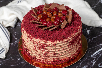 Cherry and chocolate cake. Birthday or celebration cake. Cream, cherry and chocolate cake on a dark background.