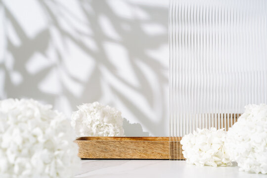 Cosmetics skin care product presentation scene made with empty wooden tray and white flowers on bathroom shelf. Studio photography.