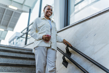 Smiling African American woman walking at the subway.