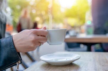 woman have a coffe with white cup  in a street cafe