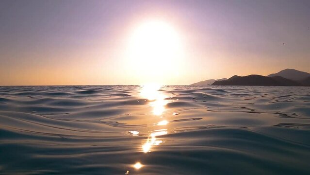 Slow motion camera rises and descends to the water level sea ocean On the Sunset. the sun's rays reflect on the water. camera emerges from the water. Turkey. High quality FullHD footage