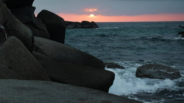 Beautiful sunset with waves breaking on the rocks, Tayrona Natural Park, Colombia
